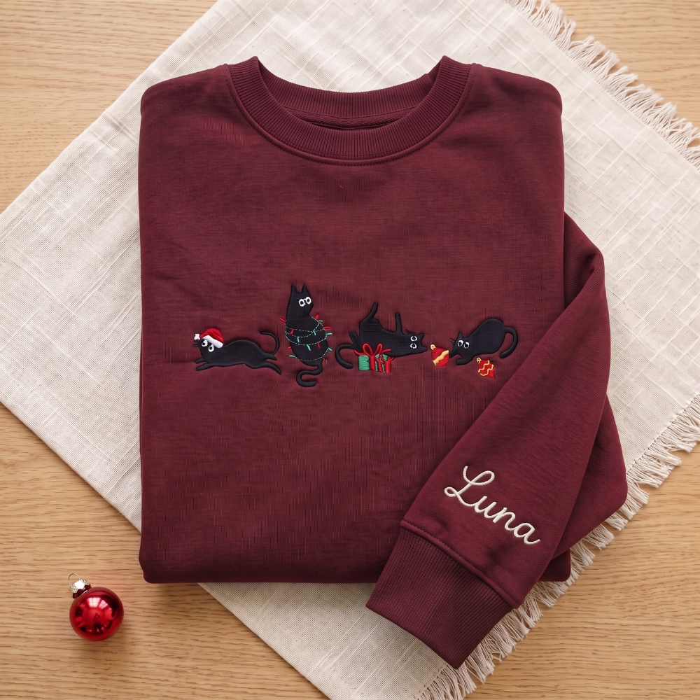 The Personalized Black Cats Christmas Mischief Santa Hat Tangled Lights Ornaments embroidered sweatshirt — front view