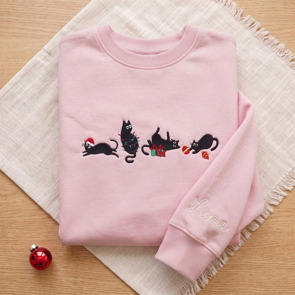The Personalized Black Cats Christmas Mischief Santa Hat Tangled Lights Ornaments embroidered sweatshirt — front view