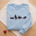 The Personalized Black Cats Christmas Mischief Santa Hat Tangled Lights Ornaments embroidered sweatshirt — front view
