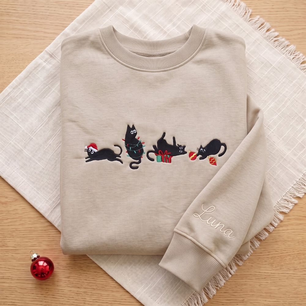 The Personalized Black Cats Christmas Mischief Santa Hat Tangled Lights Ornaments embroidered sweatshirt — front view