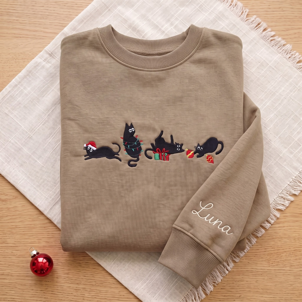 The Personalized Black Cats Christmas Mischief Santa Hat Tangled Lights Ornaments embroidered sweatshirt — front view
