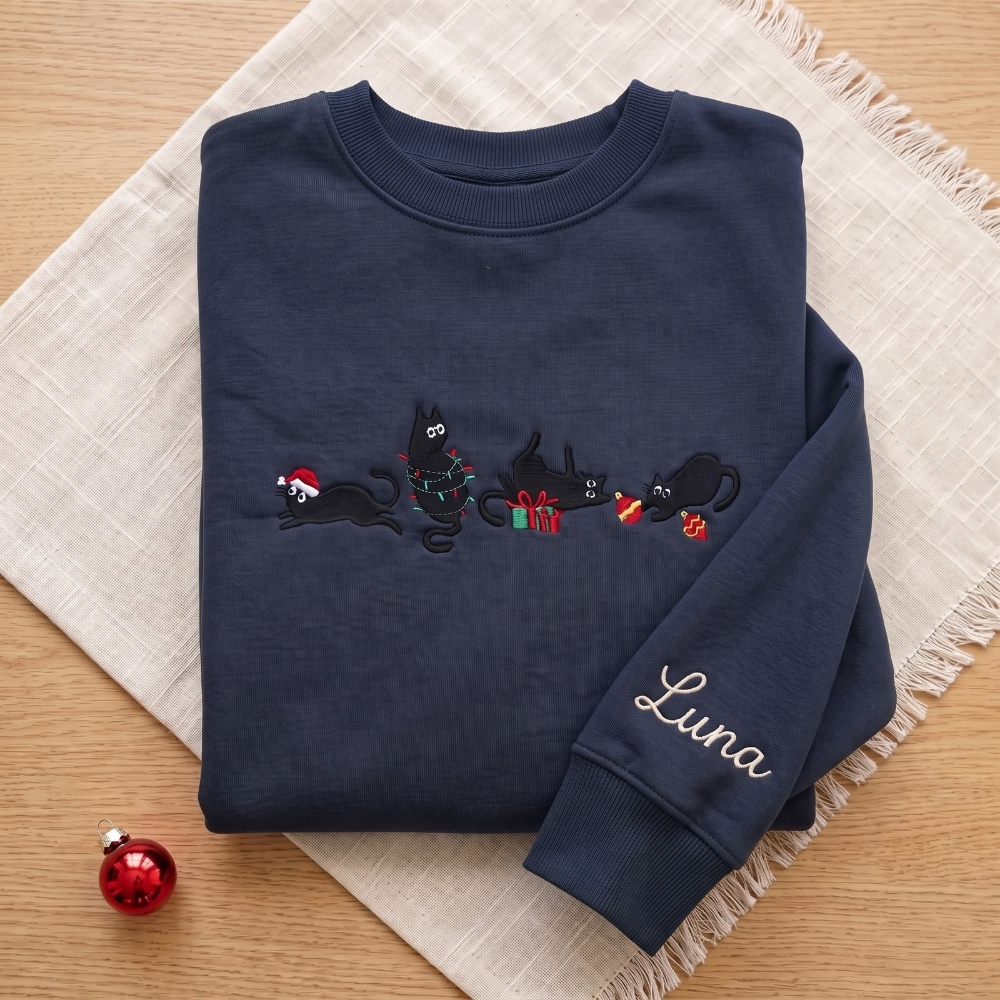 The Personalized Black Cats Christmas Mischief Santa Hat Tangled Lights Ornaments embroidered sweatshirt — front view
