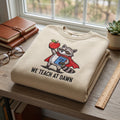 We Teach at Dawn Superhero Raccoon Teacher embroidered sweatshirt — front view