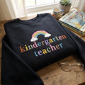 Kindergarten Teacher Pastel Rainbow Clouds embroidered sweatshirt — front view