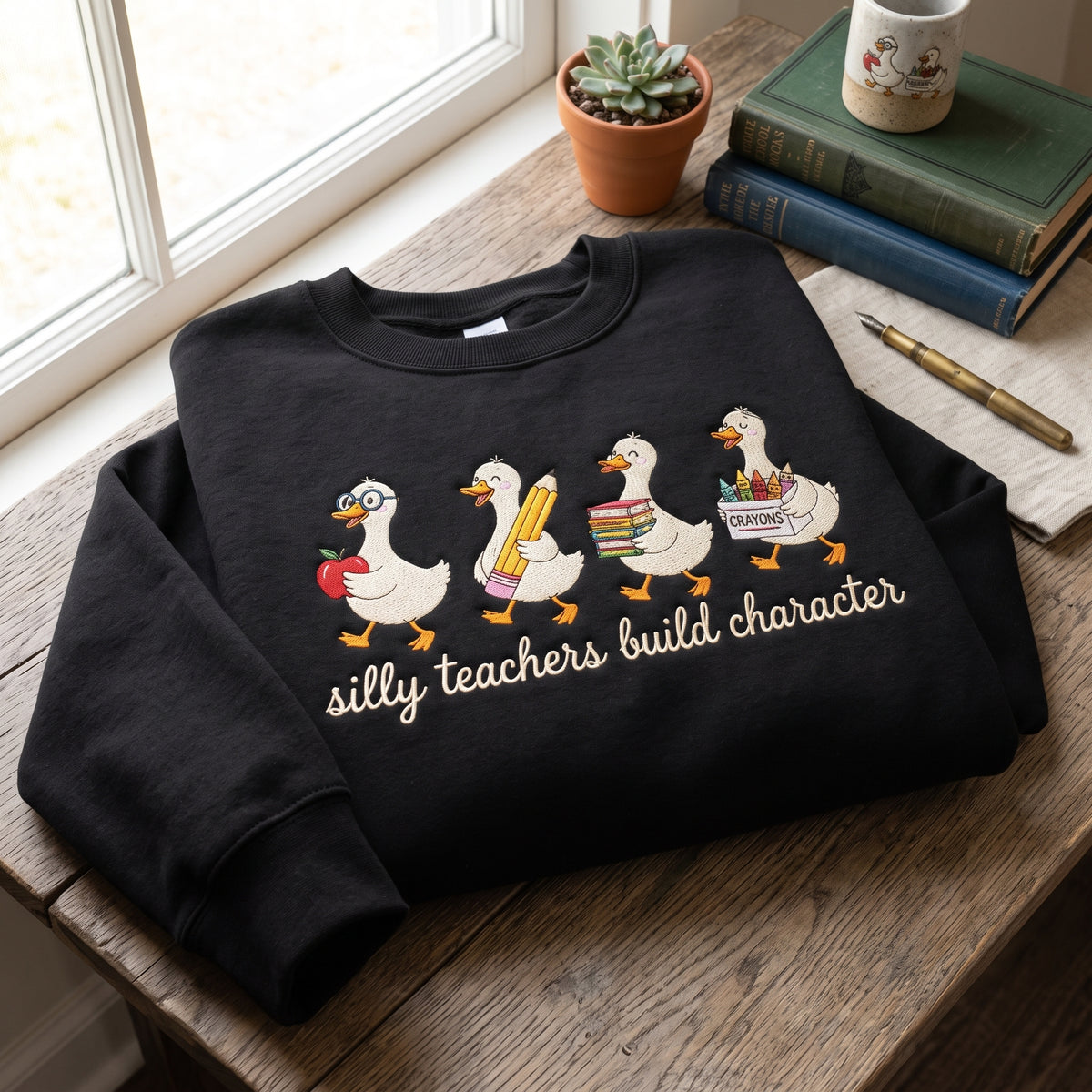 Silly Teachers Build Character Ducks Crayon Box Script embroidered sweatshirt — front view
