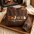 Personalized Cozy Season Fall Thread Spool Pumpkin Teapot Candle Latte Custom Sleeve embroidered sweatshirt — front view