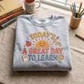Today's a Great Day to Learn Teacher Sunshine Apple Pencil Rainbow embroidered sweatshirt — front view