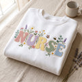 Nurse Wildflower Floral Botanical Bee Butterfly Pastel Letters embroidered sweatshirt — front view