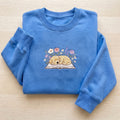 Sleeping Golden Retriever Puppy Wildflowers Open Book embroidered sweatshirt — front view