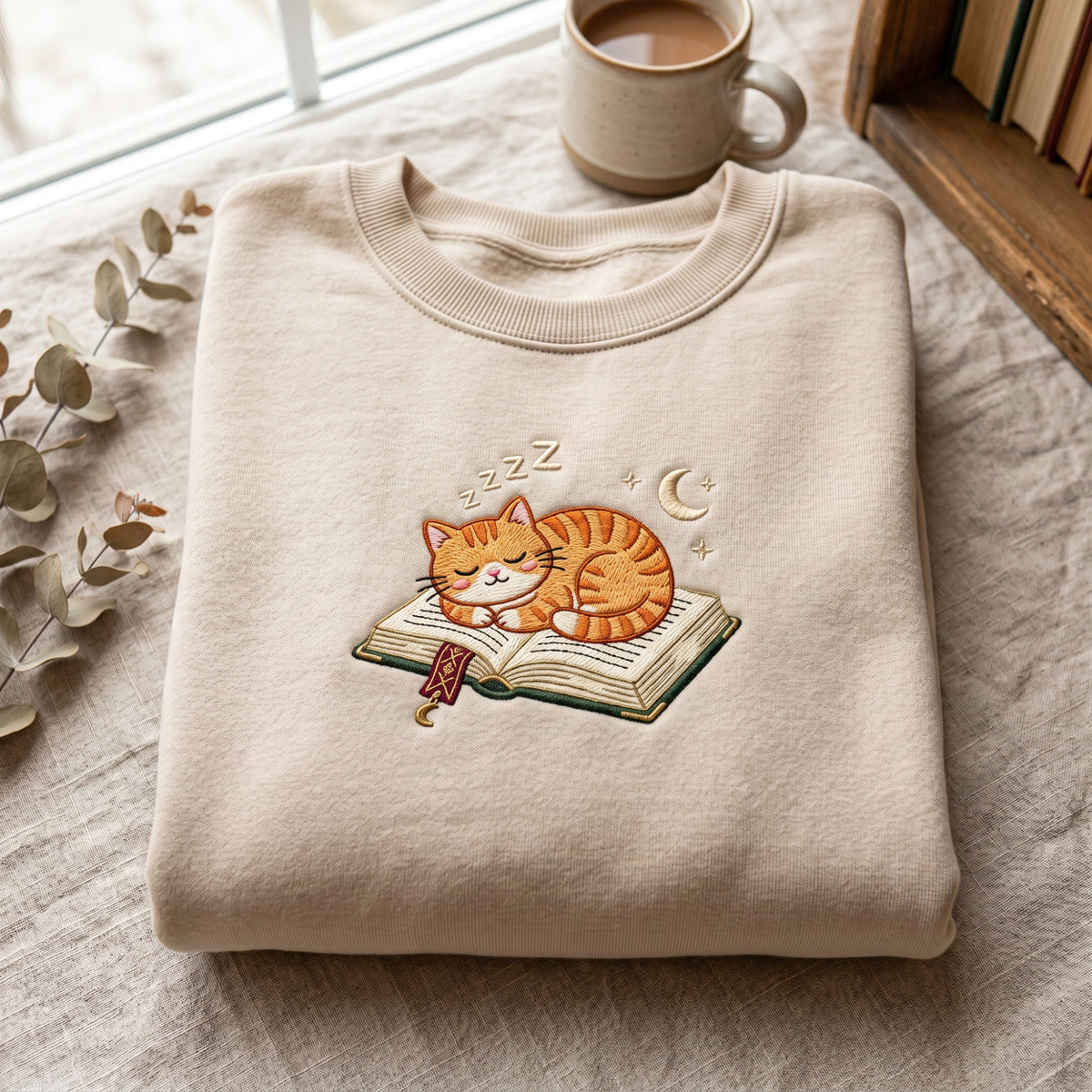 Sleeping Cat on Book Zzz Moon Stars Cozy Reader embroidered sweatshirt — front view