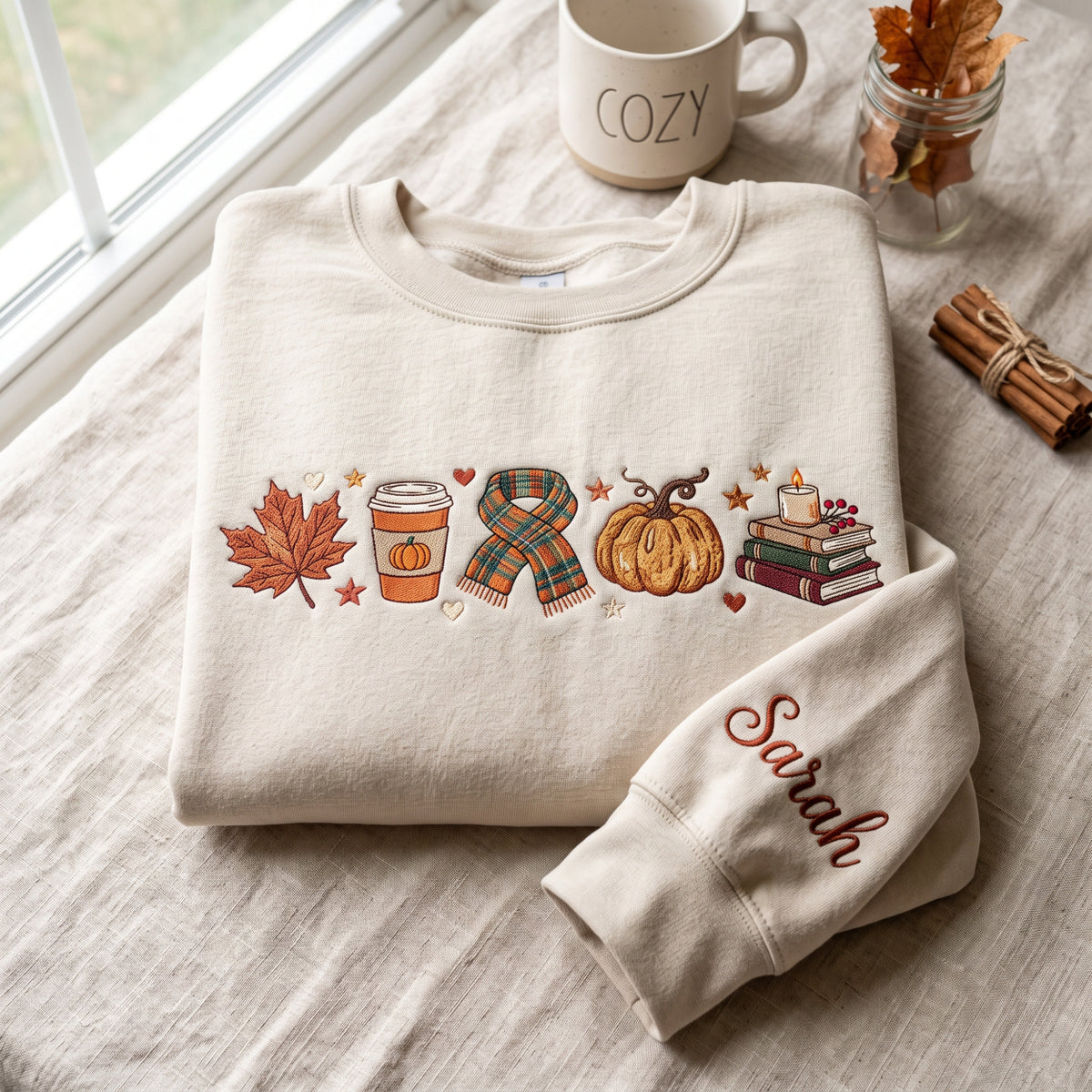 Personalized Cozy Fall Autumn Maple Leaf Pumpkin Latte Scarf Books Candle Sleeve Name embroidered sweatshirt — front view