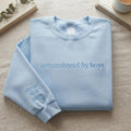 Personalized Outnumbered by Boys Mom Names on Sleeve Tone on Tone embroidered sweatshirt — front view