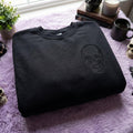 Skull Left Chest Tonal Black Halloween Goth embroidered sweatshirt — front view