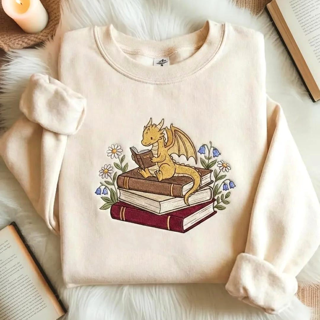 Baby Dragon Reading Book Stacked Books Wildflowers Daisy Bluebell embroidered sweatshirt — front view