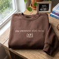The Sweetest Plot Twist Baby Feet Book Pregnancy Announcement embroidered sweatshirt — front view