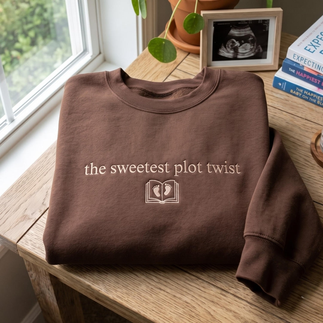 The Sweetest Plot Twist Baby Feet Book Pregnancy Announcement embroidered sweatshirt — front view