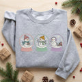 Three Snowman Snow Globe Pastel Christmas Winter Holiday embroidered sweatshirt — front view