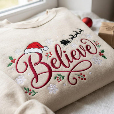Christmas Believe Santa Hat Reindeer Sleigh Holly Snowflakes embroidered sweatshirt — front view