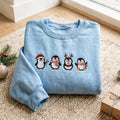 Christmas Penguins Santa Hat Reindeer Antlers Candy Cane Hot Cocoa Holiday embroidered sweatshirt — front view