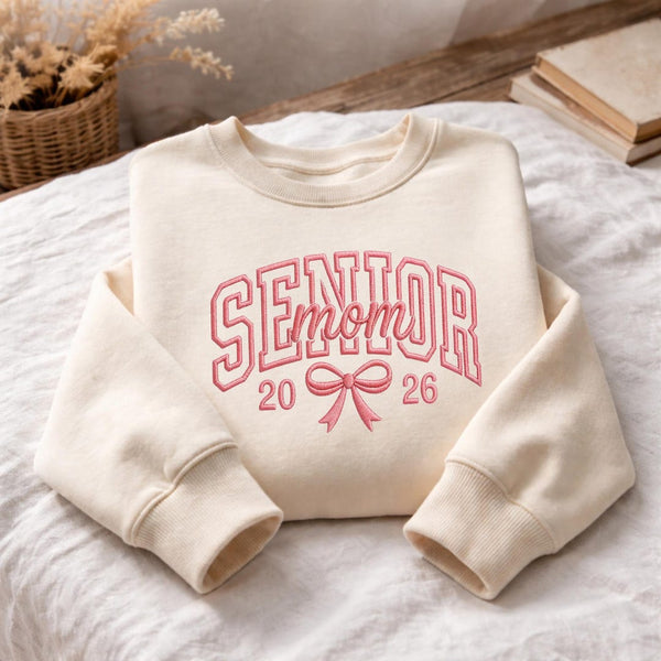Senior Mom 2026 Coquette Bow Varsity Arch embroidered sweatshirt — front view