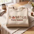 Cozy Season Fall Icons Pumpkin Mittens Candle Book Coffee embroidered sweatshirt - front view
